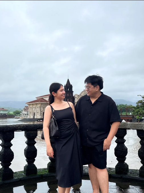 A couple photo together by the riverside in black outfits.